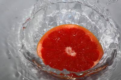 Красный грейпфрут и брызги воды